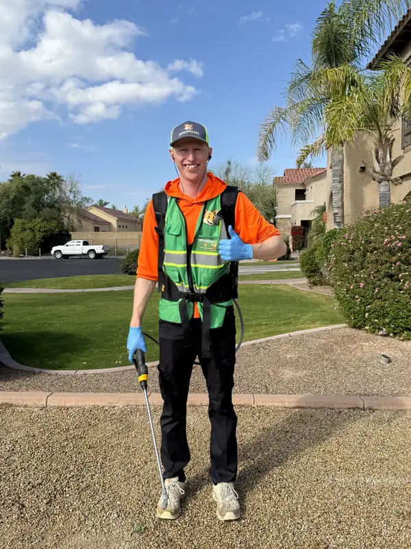 Seth Bell-Eros, owner of Arrowscape Lawn Care Services, wearing branded safety gear while servicing a West Valley property